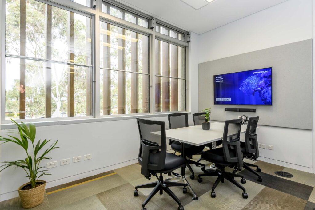 Small group study room at the Melton Suburban University Study Hub with a large display screen and natural light.